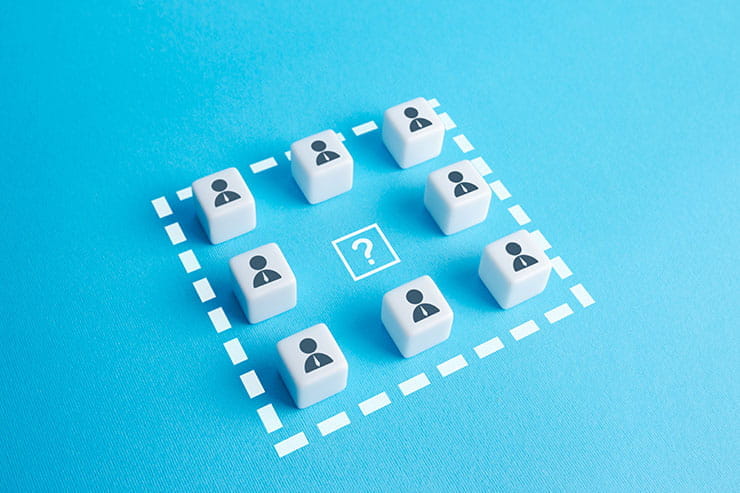 Eight dice with figures of people on them surrounding a question mark; visual representation of recruitment. 