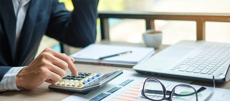 Establishing pay rates: Businessman using calculator for analysis