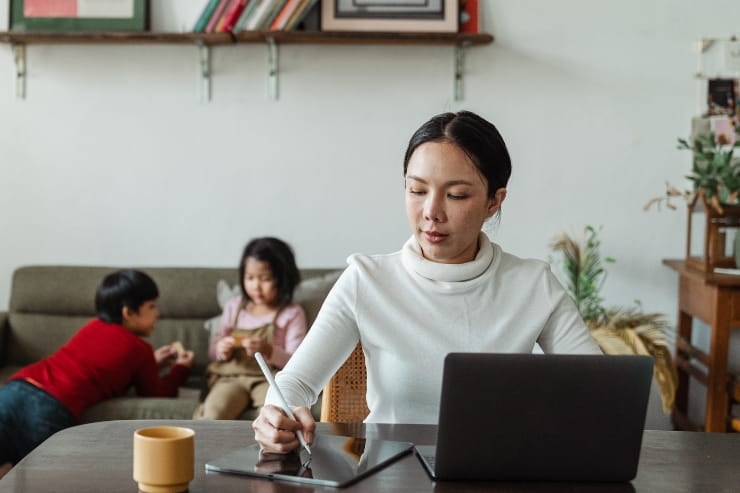 woman working from home with two kids in the background