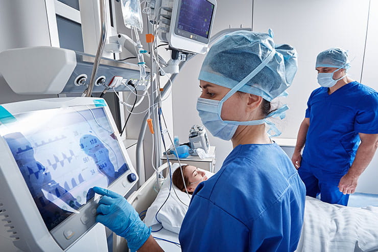 Infirmières surveillant les signes vitaux du patient dans l'unité de soins intensifs.