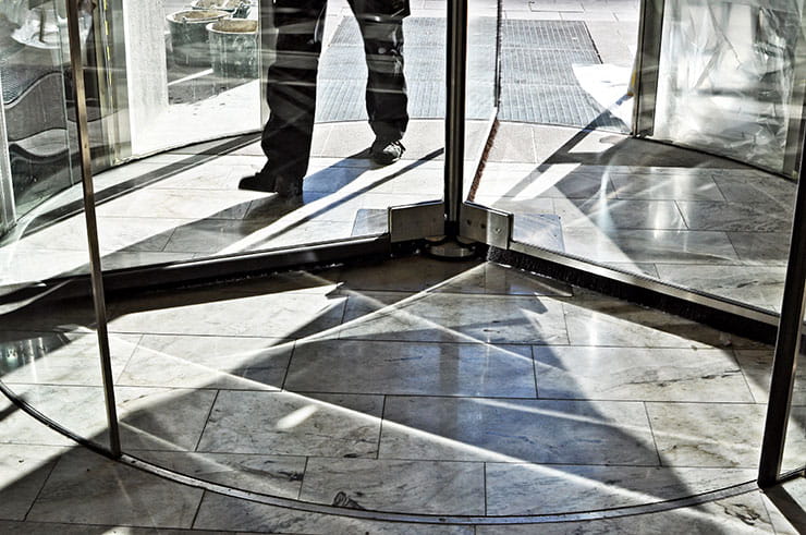 Professional worker exiting the office through a revolving door