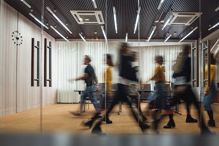 Image floue de gens qui marchent dans un espace de bureau