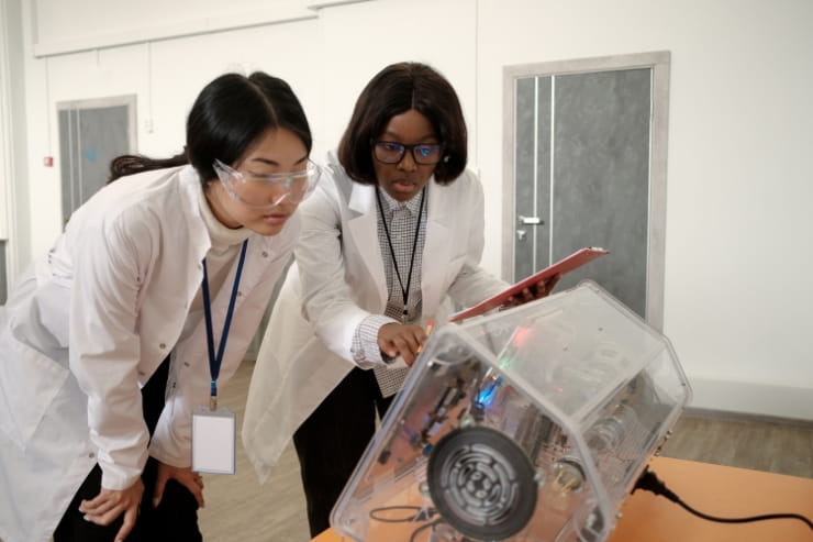 Une ingénieure en logiciel et une scientifique testent des machines électriques dans un laboratoire de robotique.