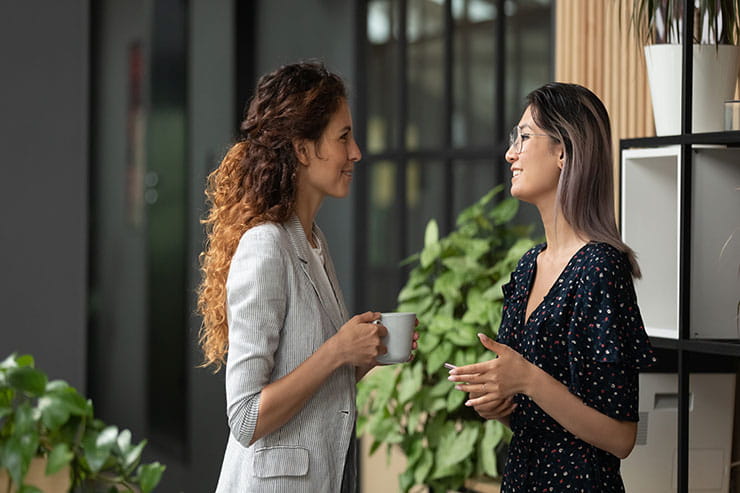 Two women having a casual conversation over coffee. 