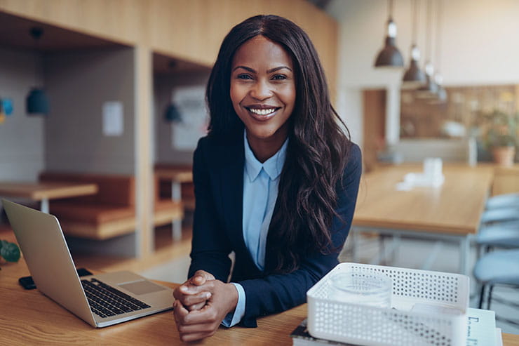 LinkedIn personal branding: Smiling woman in suit sitting at laptop
