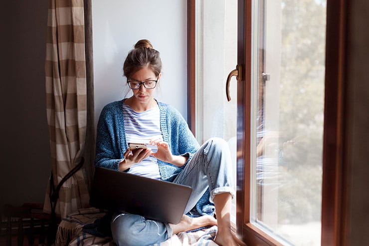 Social distancing in Covid-19 outbreak: Young woman working from home office.