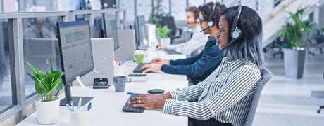 people working at computers wearing headsets
