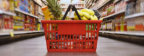 Groceries in a basket on
                the floor of a store