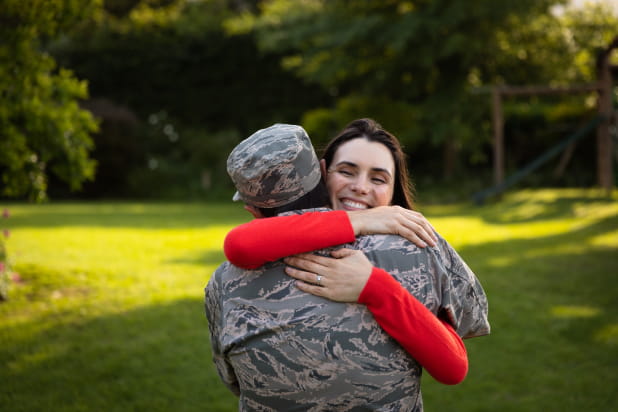 Male Military member embraces young female