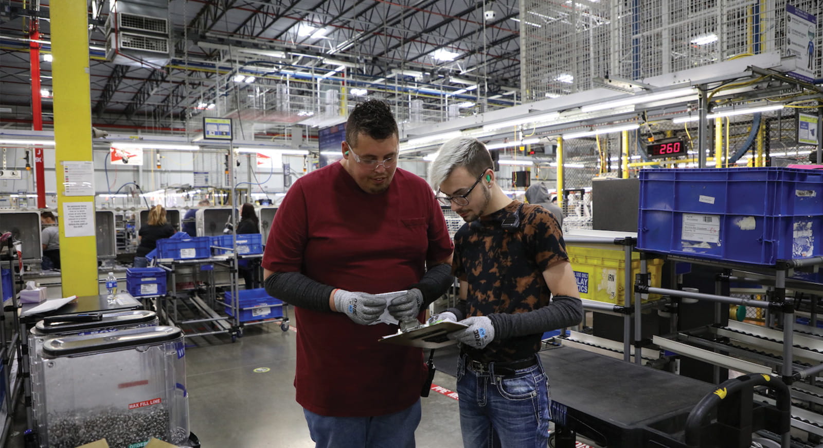Two Whirlpool employees reviewing information on a clipboard